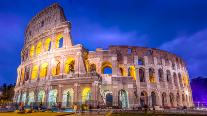 Roman Colosseum and tourists as night falls in Rome, Italy, blurred faces for commercial use