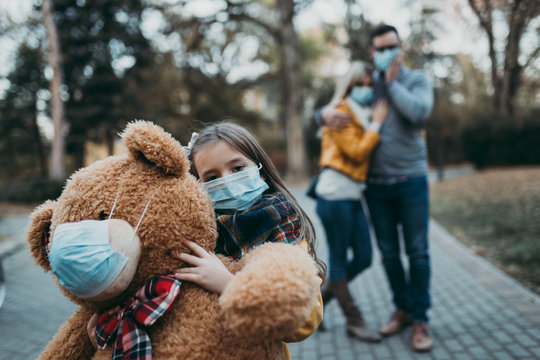 Young family in protective mask outdoors in park. Air pollution concept.