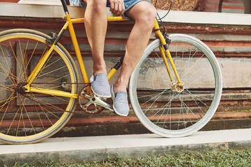 Naklejka premium Attractive man sitting with old bicycle.