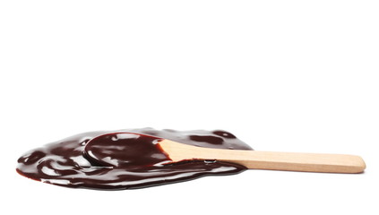 Melted chocolate for topping with wooden spoon isolated on white background, clipping path