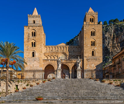 The facade of the Cathedral-Basilica of Cefalu features two large Norman towers, with mullioned windows in Sicily, Italy