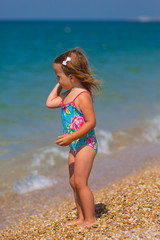 Cute little girl playing on the seashore