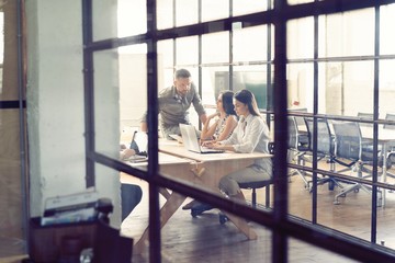 Young creative people in modern office. Group of young business people are working together with laptop, tablet, smart phone, notebook. Successful hipster team in coworking. Freelancers.