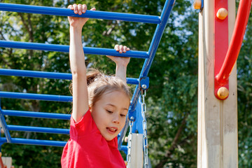 Obraz premium A girl climbs the stairs on the playground in the park