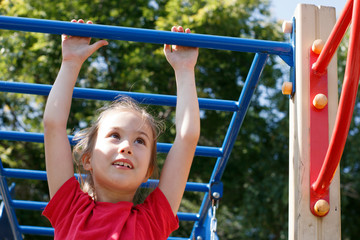 Obraz premium A girl climbs the stairs on the playground in the park