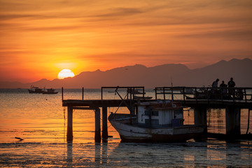 Fototapeta premium beautiful sunset on the pier of the guaratiba stone (pedra de guaratiba), in the west side of rio de janeiro, brazil