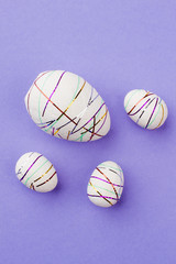 Styrofoam eggs on purple background. Easter decorative eggs on colorful background, top view. How to decorate eggs for Easter holidays. Easter craft ideas.