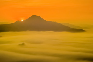 sunrise at Phu Thok (phu tok) View Point, beautiful mountain view of top mountain around with sea of mist with orange sun light in the sky background, Chiang Khan District, Loei Province, Thailand.