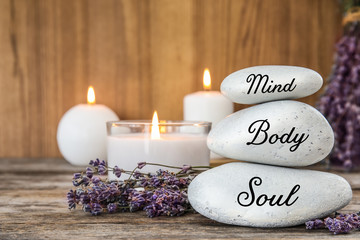 Spa stones with lavender flowers and candles on table