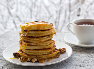 pancakes with honey and nuts, a cup of tea, breakfast, view of the winter landscape