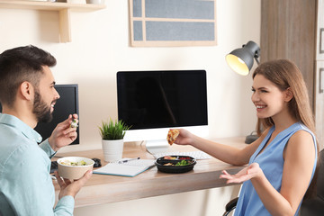 Office employees having lunch at workplace. Food delivery
