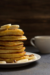 pancakes with honey and nuts, a cup of tea, breakfast, dark background