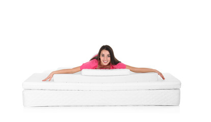Young woman lying on mattress pile against white background