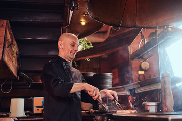 Focused master chef cooking delicious beef steak on a kitchen in a restaurant.