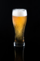 Draft beer in glass on black background