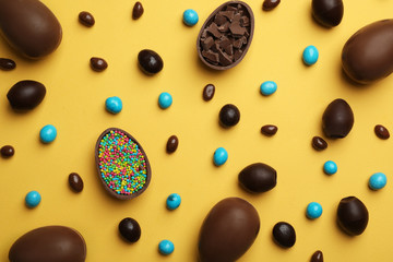 Flat lay composition with chocolate Easter eggs on color background