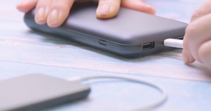 Hand holding USB type C into power bank. Closeup.