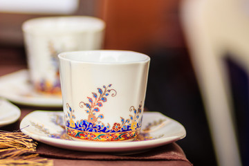 Vintage Thai's style porcelain coffee cup handmade. Beautiful traditional Thai five-colored porcelain ceramic coffee cup. Benjarong Porcelain coffee cup for sale in the flea market, Thailand.