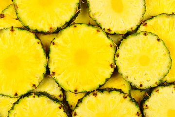 Pineapple juicy yellow slices background. Top view.