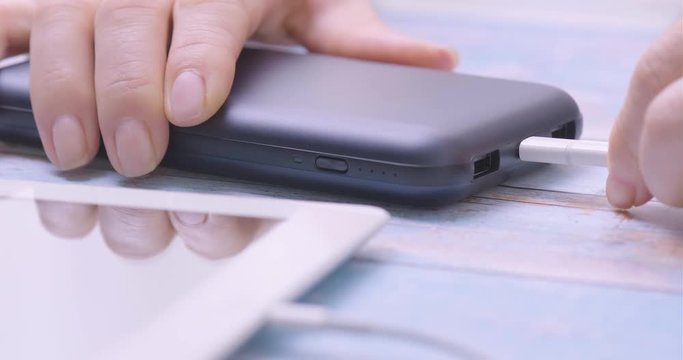 Hand holding USB type-C into power bank. Closeup.