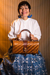 Femme assise avec un sac à main en osier