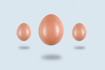 three Levitating eggs on a light background, conceptual Easter postcard