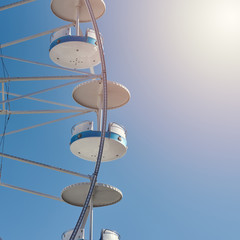 Panoramic wheel in amusement park against clear blue sky. Close view.