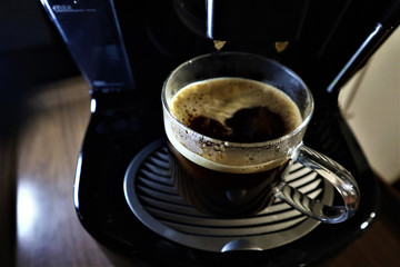 Coffee machine pouring coffee in cups.