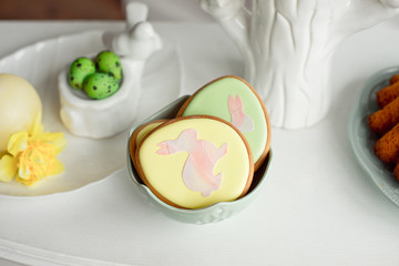 Easter spring decorative composition with homemade easter cookies in the shape of a funny rabbit, quail eggs