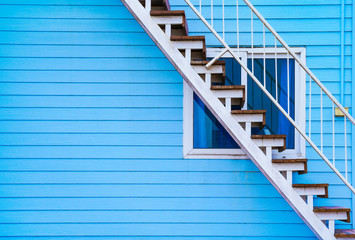 Home exterior design - Blue wooden house’s wall and stairs to upper floor