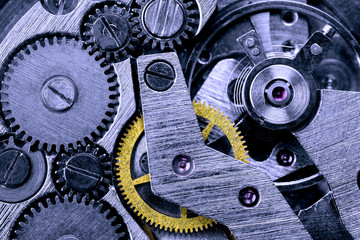 Gears of a mechanical watch close-up with blue toning