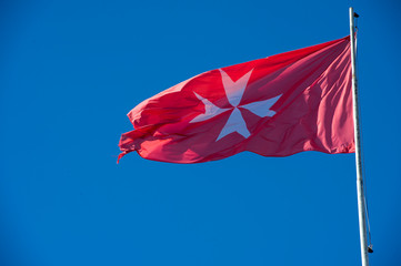 Fototapeta premium Rome, February 07, 2018: Flag of the Works of the Sovereign Military Order of Malta over the Villa del Priorato di Malta.