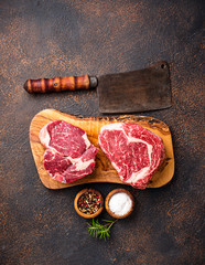 Raw marbled ribeye steak and butchers knife