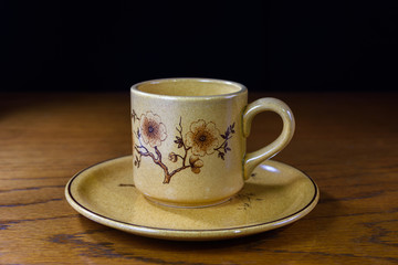 Taza de café con plato en mesa de madera