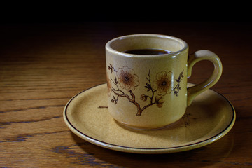 Taza de café con plato en mesa de madera