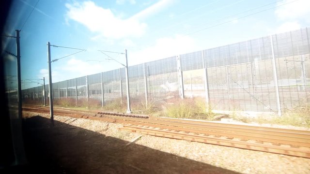 Approaching the Eurotunnel Getlink fast view from train Eurostar window with security fences along the path 