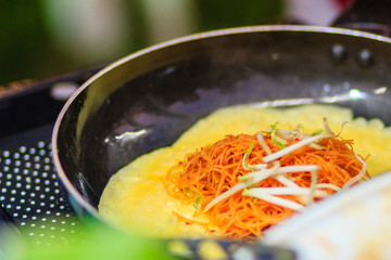 Close up hand of vendor during cooking for the original Thai Fried Noodle(Pad Mee Boran), stir-fried noodle with shrimp and egg commonly served as a street food popular in Thailand