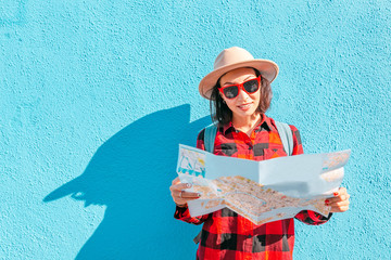 a young happy asian girl in a hat travels with a map in Burano, Venice