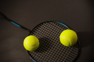 tennis ball and racket on dark
