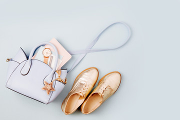 Cute blue ladies bag, stylish golden shoes and  feminine accessories . Flat lay, top view. Spring...