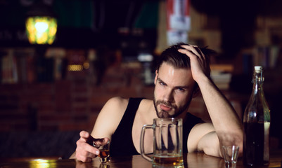Drinking alcohol may help him relax. Alcohol addict with short alcohol drink. Alcoholic man drinking at bar counter. Man drink strong alcoholic beverage and beer in pub. Bad habit