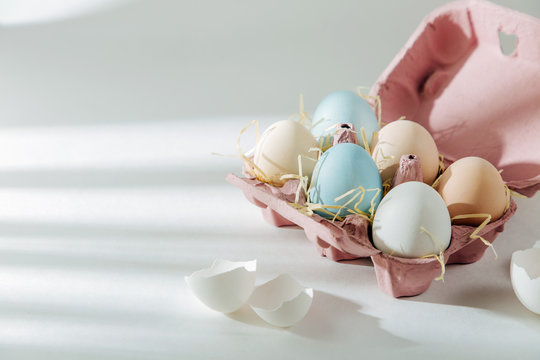 Natural Colored brown and white Eggs in egg box with sunlights.. Compositions in pastel colors. Easter consept.