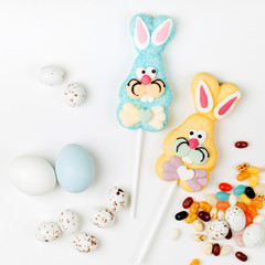 Easter candy chocolate eggs and Jellybean with sweet Easter bunny on white background. Flat lay, top view