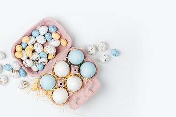 Easter eggs and candies in a box. Compositions in pastel colors. Flat lay, top view