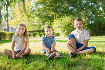 Fototapeta na wymiar Children sit on the fresh green grass