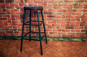 high stool against the background of a red brick wall