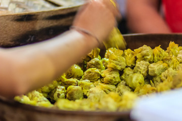 Close up street vendor during cooking and selling for Steamed shrimp pork shumai to customer at night market.