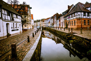Naklejka premium Bachlauf mit Spiegelung in historischer Stadt Wismar