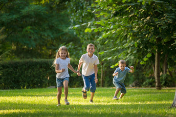 Fototapeta premium Boys and girl play and run a race on the lawn outdoor
