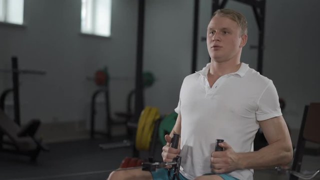 Handsome bodybuilder works out in gym